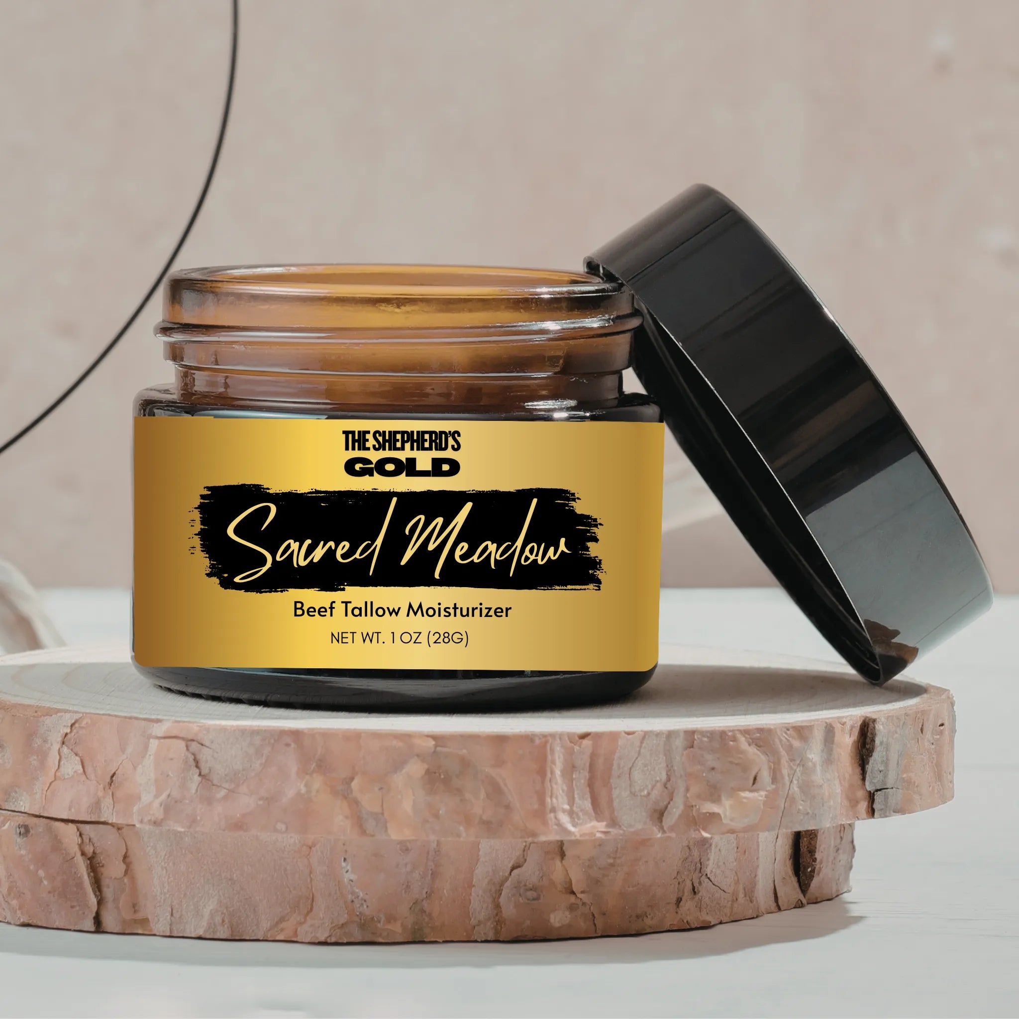 Shepherd's Gold Sacred Meadow beef tallow moisturizer jar on a wooden platform with a neutral background